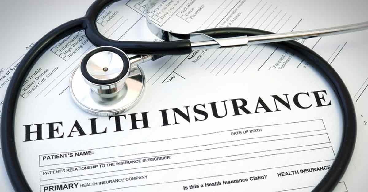 A stethoscope lies on top of health insurance document health plans