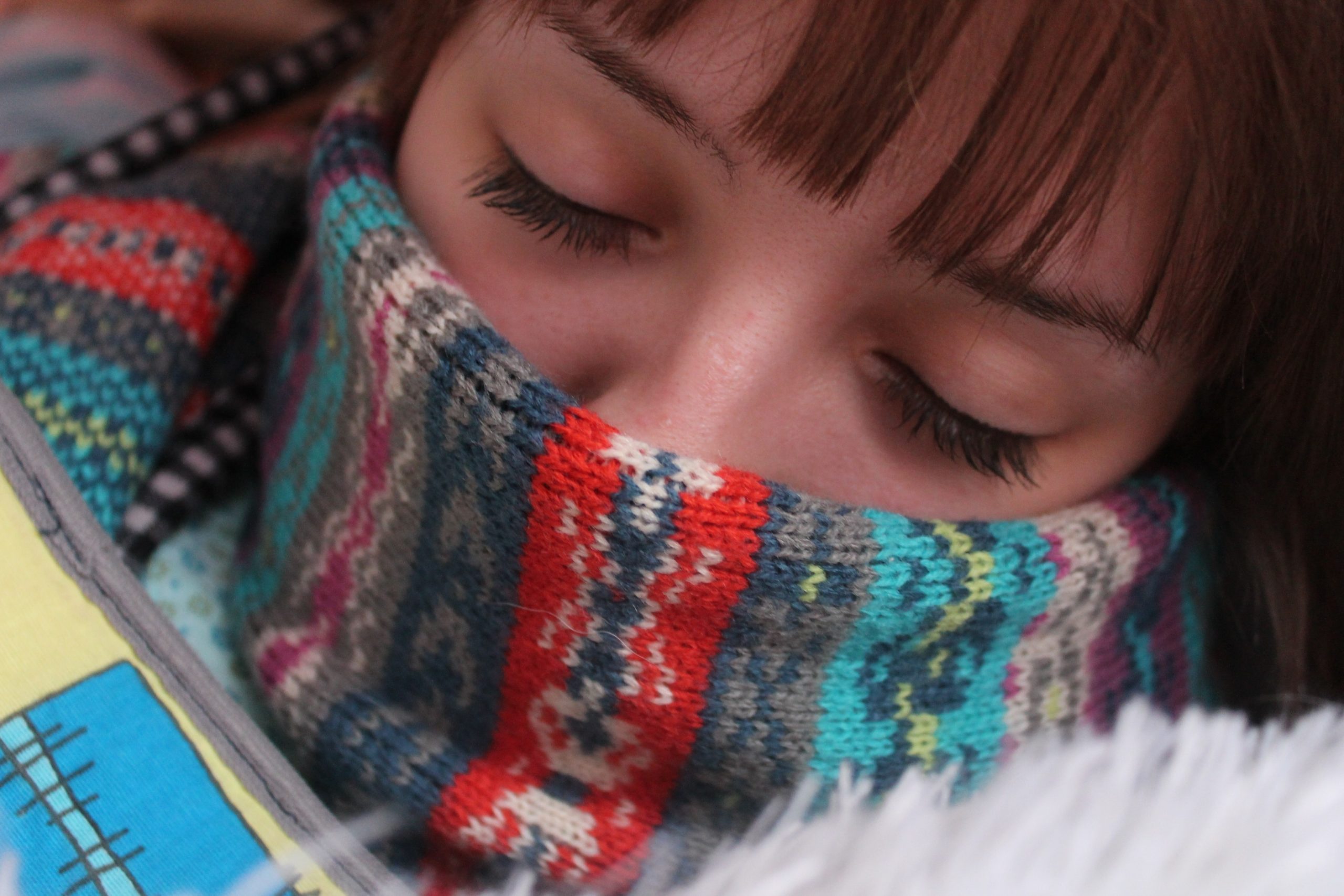 Sick woman with scarf over nose during cold and flu season