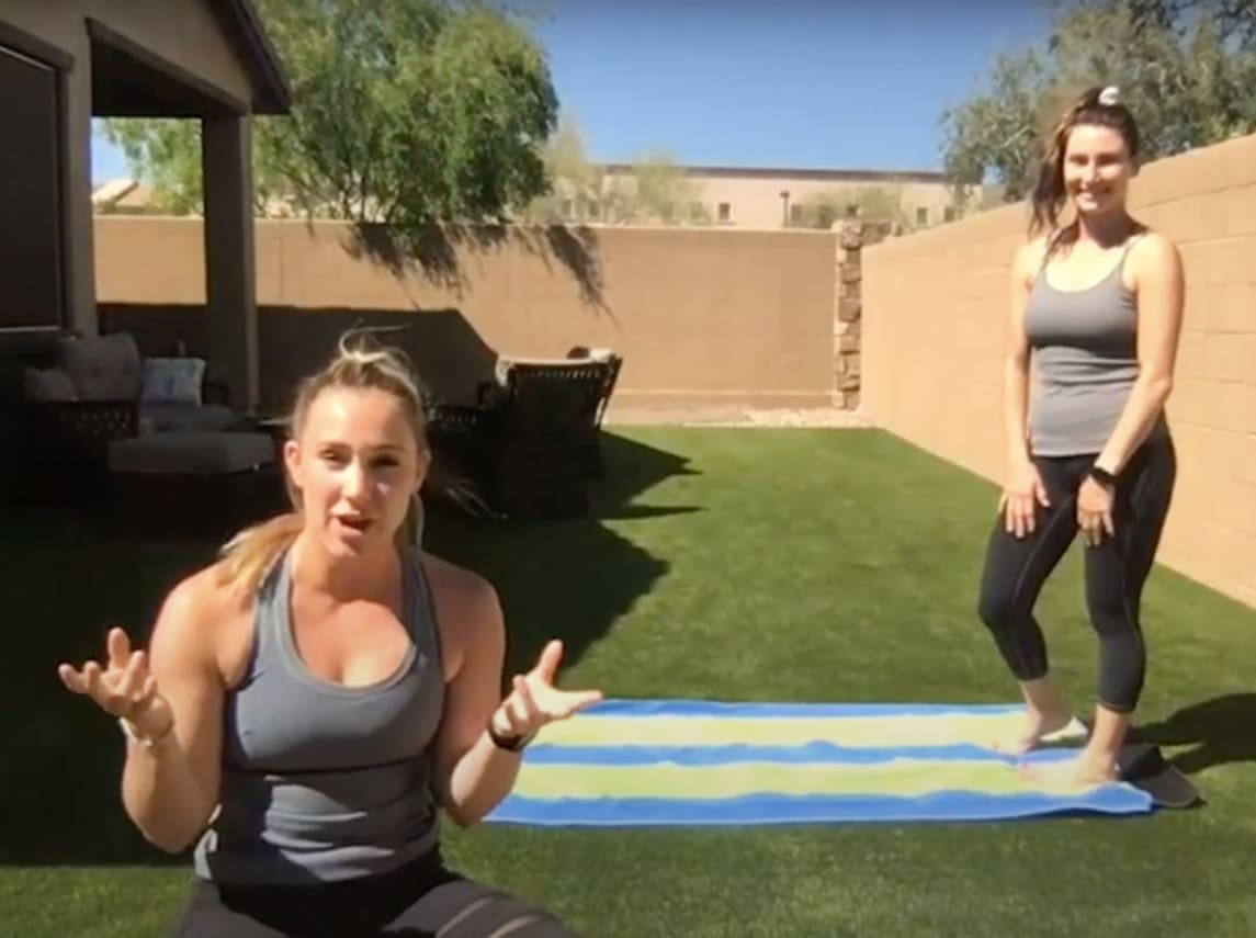 Two females are in the backyard doing yoga