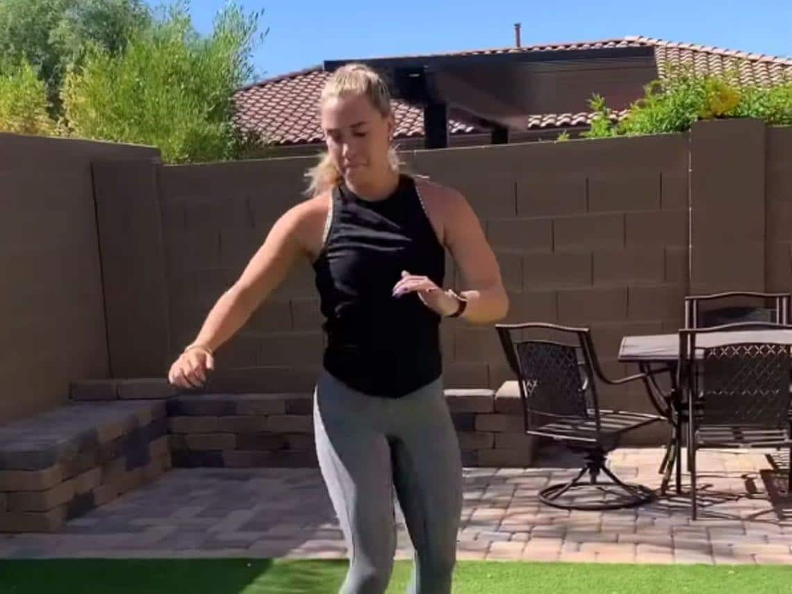 A woman doing her workout in her backyard