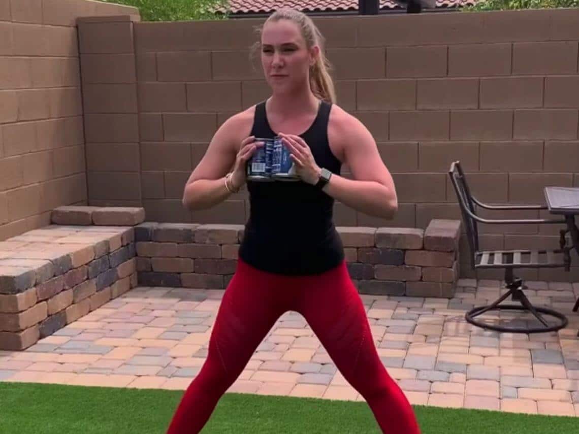 A woman is in her backyard doing a full body workout